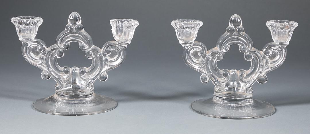 Pair of Two-Light Glass Candelabra: Pair of Two-Light Glass Candelabra , scrollwork motif, h. 5 1/2 in., w. 7 in., d. 5 1/2 in; Condition: one with partial loss to bobeche IMPORTANT: All purchases must be removed from our premises withi