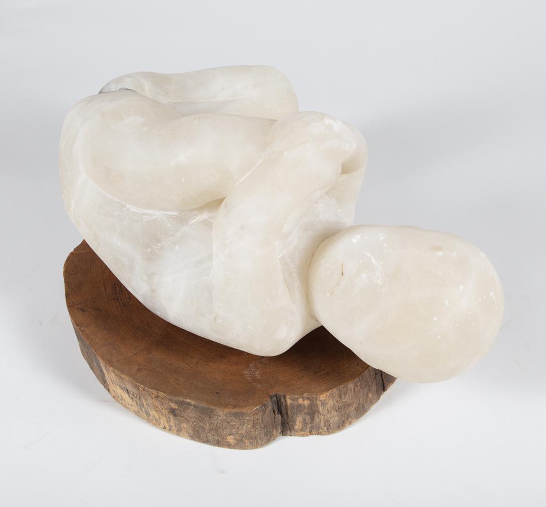Robert Cook (American, 1921-2017): Robert Cook (American, 1921-2017) , "Alabaster Baby", 1952, alabaster with wood base, unsigned, h. 8 in., w. 15 in., d 9 in., overall h. 10 in. (2 pcs.) . Condition Report: Surface dirt; scattered mar