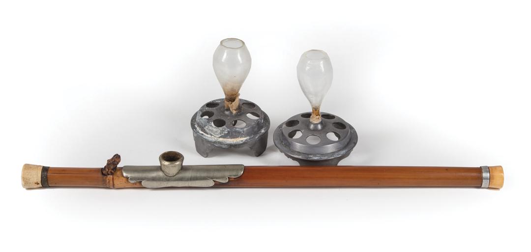 Carved Wood and Metal Opium Pipe: Carved Wood and Metal Opium Pipe , figural wood ornament, l. 20 1/8 in.; TOGETHER WITH two glass and metal oil lamps, h. 5 in.; Condition: pipe: surface dirt; shrinkage; metal bowl is loose; surface m