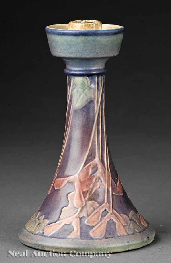 Newcomb College Art Pottery Candlestick: A Newcomb College Art Pottery Matte Glaze Candlestick, 1919, decorated by Henrietta Bailey with a maple wing motif in blue, green and pink underglaze, the base retaining original paper label and marke