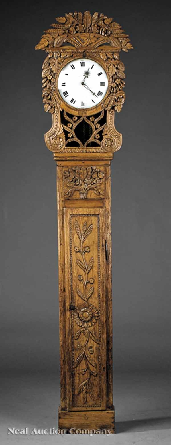 French Provincial Carved Pine Tall Case Clock: A French Provincial Carved Pine Tall Case Clock, c. 1800, Normandy, heavily carved with bouquets, rosettes and vining plants, porcelain dial, striking bell movement, height 89 in., width 20 in., depth