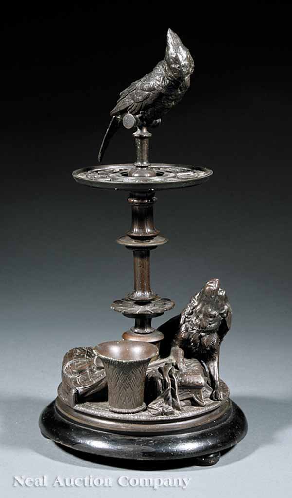 English Patinated Metal Figural Pipe Stand: An Antique English Patinated Metal Figural Pipe Stand, late 19th c., the standard modeled as a parakeet perched above a dog, shaped wood base, bun feet, height 15 in., diameter 7 1/2 in