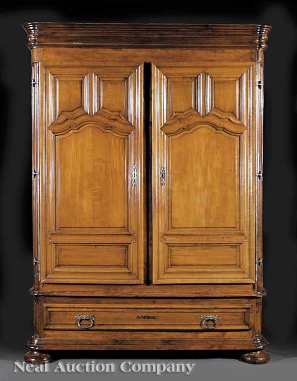 Provincial Louis XV Carved Fruitwood Armoire: An Antique Provincial Louis XV Carved Fruitwood Armoire , 18th c. and later, stepped cornice, scalloped raised panel doors, arched raised panel sides, the base with long drawer on massive bun feet , h
