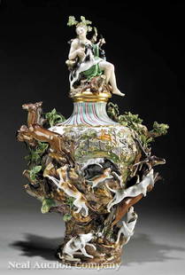 A Meissen Polychrome Urn, depicting "The Hunt": A Large Meissen Polychrome and Gilt-Decorated Porcelain Figural Covered Urn, 19th c., depicting "The Hunt", the body highly modeled with hounds chasing a stag, doe, and wild boar and reserved with a h