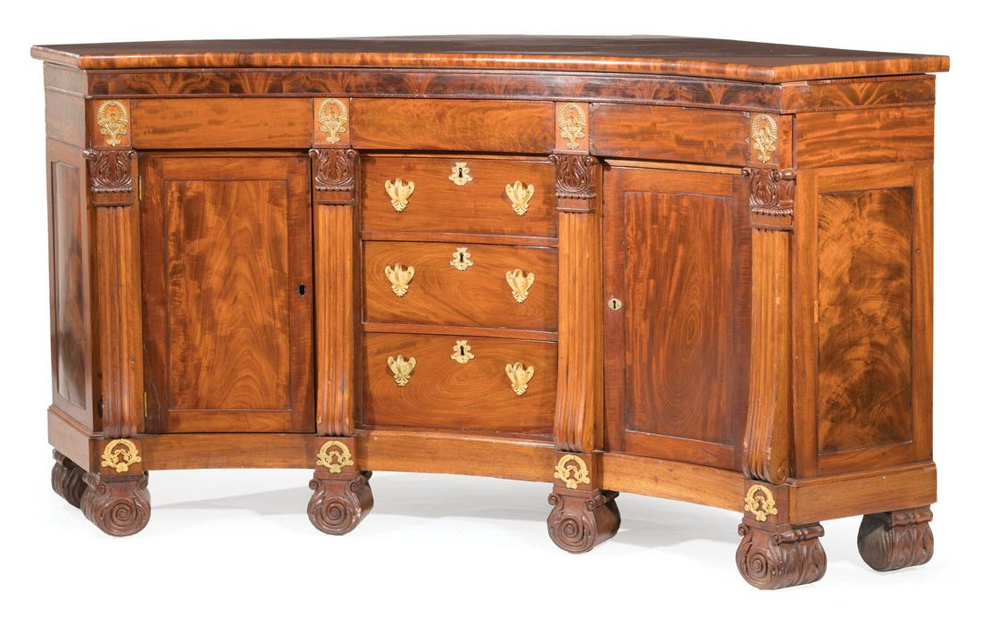 American Carved Mahogany Corner Sidebaord: American Late Classical Bronze-Mounted Carved Mahogany Corner Sideboard , early-to-mid 19th c., shaped top, blind frieze drawers, foliate capitals over reeded scroll pilasters, three central drawers,