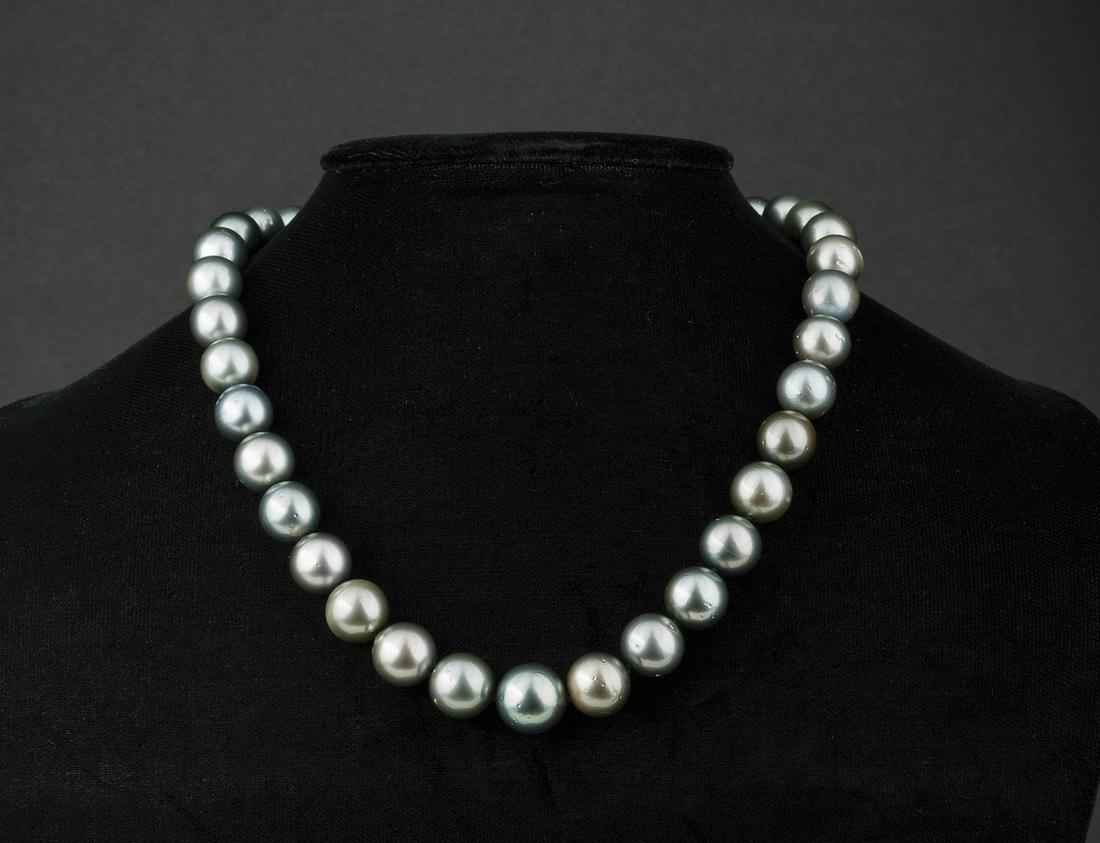 Gold and Tahitian Pearl Necklace: 14 kt. White Gold and Tahitian Pearl Necklace , 35 round/off round graduated Dark Gray cultured pearls, 11-14 mm; 14 kt. white gold plunger style clasp, l. (incl. clasp) 17 3/4 in.; AIGL report. **Ple