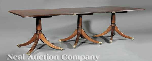 Regency-Style Mahogany Dining Table: A Regency-Style Mahogany Dining Table, top in three parts above a turned stem, saber legs, brass paw feet, casters, height 29 in., closed length 70 in., extended length 108 in., depth 45 in
