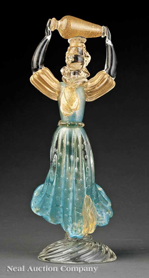 Flavio Poli Murano Art Glass Figure: A Flavio Poli Murano Art Glass Figure, mid-20th c., depicting a peasant woman carrying a jug aloft, turquoise bubbled dress, gold leaf throughout, swirled base, height 13 3/8 in