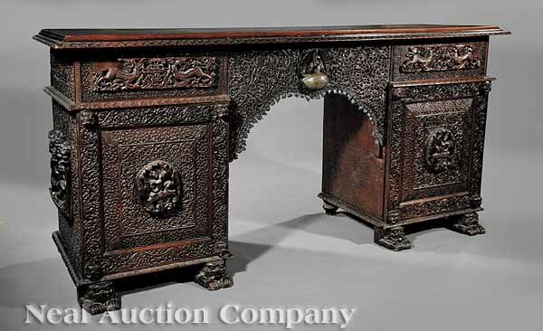 Burmese Highly Carved Hardwood Sideboard: An Antique Burmese Highly Carved Hardwood Sideboard, 19th c., the top with foliate molding above two pedestal cabinets, each having a drawer above doors opening to sliding trays and drawers, the cente