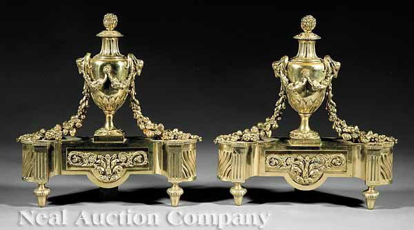 Pair of Empire-Style Gilt Brass Andirons: A Pair of Empire-Style Gilt Brass Andirons, c. 1900, urn standard, flanked by ram's heads and fruit swags, fluted base on toupie feet, height 14 in., width 13 in., depth 4 in