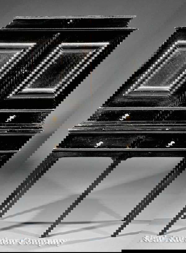 Spanish or Portuguese Ebonized Vargueno: An Antique Spanish or Portuguese Ebonized Vargueno, 19th c., lift top above a pair of ripple molded doors opening to mirrored inlaid amphitheater surrounded by drawers, molded base with two short over