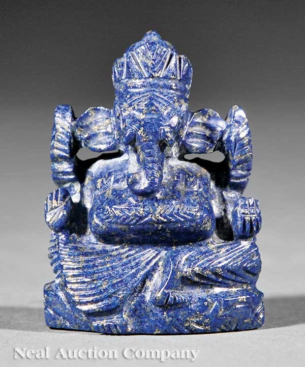 Carved Lapis Lazuli Figure of Ganesh: A Southeast Asian Carved Lapis Lazuli Figure of Ganesh, the crowned elephant-figure carved seated in the position of royal ease upon a throne, height 2 5/8 in., width 2 in., associated wood stand