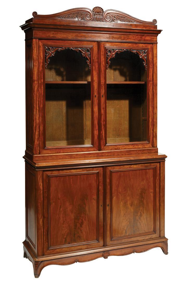 Large English Carved Mahogany Bookcase: Large English Carved Mahogany Bookcase, mid-19th c., scroll and shell carved pediment over bookcase with glazed doors, lower case with paneled doors, carved apron, cabriole bracket feet, plum pudding