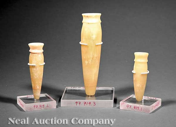 Three Egyptian Alabaster Alabastra: A Group of Three Egyptian Alabaster Alabastra, each of conical form with waisted flared neck and mouth, heights 8 1/8 in., 5 1/2 in., and 4 3/4 in., museum mounts