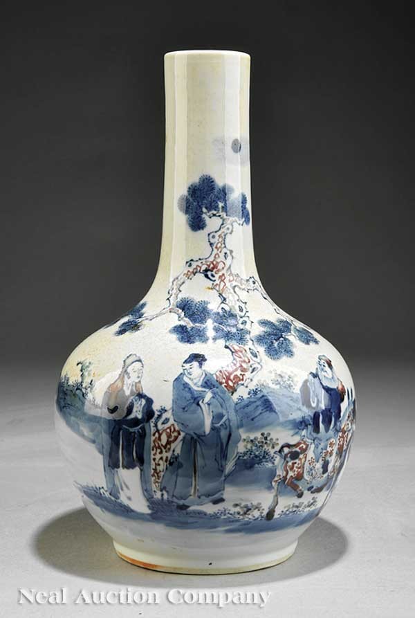Red Decorated Blue and White Porcelain Bottle Vas: An Antique Chinese Red Decorated Blue and White Porcelain Bottle Vase, the globular body and tall cylindrical neck decorated with figures in a landscape beneath an old pine, recessed base with circula