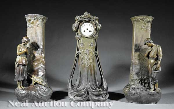 Art Nouveau Patinated Metal Three Piece Clock Gar: An Art Nouveau Patinated Metal Three Piece Clock Garniture, c. 1900, sinuous floriform clock case with porcelain dial, the vases flanked by peasant figures, each piece signed "A. de Ranier", clock hei
