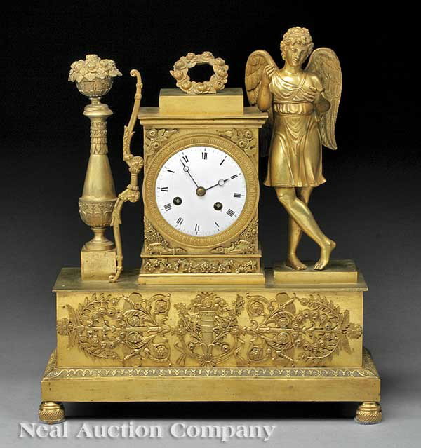 Charles X Bronze Dore Figural Mantel Clock: A Charles X Bronze Dore Figural Mantel Clock, early 19th c., the figure of Amore resting on the case, accompanied by his bow and wreath, tall plinth base with trophee mounts, height 14 1/2 in., width 