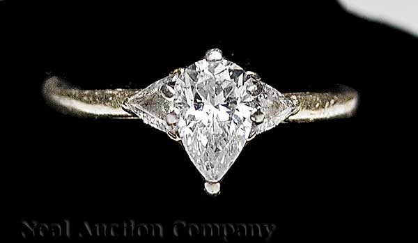 14 kt. Yellow Gold and Diamond Solitaire Ring: A 14 kt. Yellow Gold and Diamond Solitaire Ring, the pear-shaped center stone approx. .50 cts., flanked by 2 trillions totaling approx. .30 cts