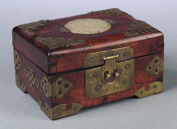 A Chinese Export Hardwood Box: A Chinese Export Hardwood Box , late 19th c., with extensive brass mounts and a carved mutton fat jade roundel on lid, height 2 7/8 in., length 5 1/8 in., width 4 in* NO RETURNS ARE ACCEPTED ON THE BA