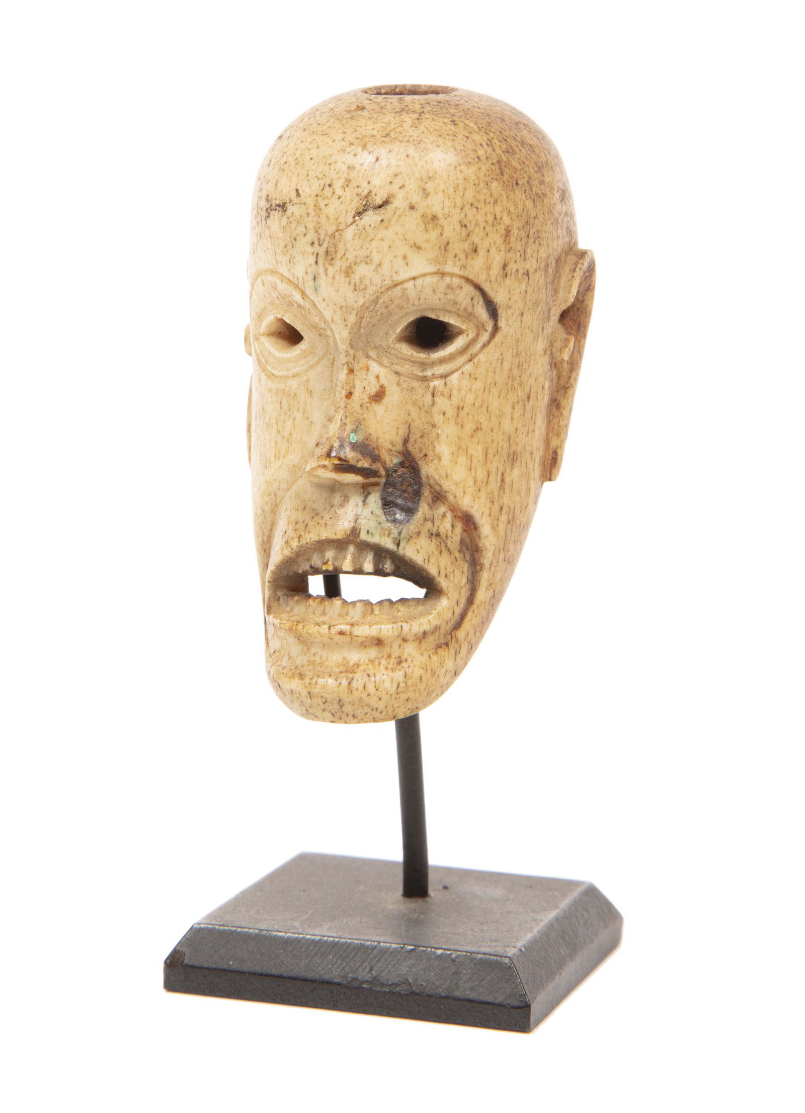 Oceanic Batak Carved Bone Mask Pendant or Charm: Oceanic Batak Carved Bone Mask Pendant or Charm, Northern Sumatra, Indonesia, h. 2 3/8 in., stand, overall h. 3 3/8 in Provenance: Abba Kastin, New Orleans, June 1994; Estate of Curator and Scholar an