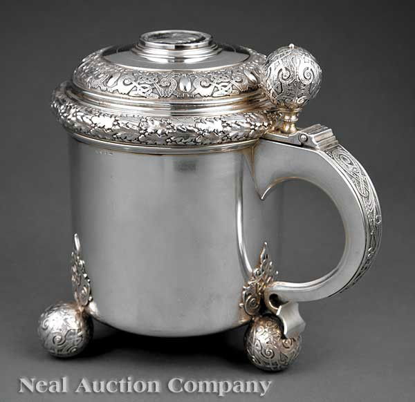 C.G. Hallberg Sterling Silver Tankard: An Antique Swedish Sterling Silver Tankard, C.G. Hallberg, Stockholm, 1901, plain cylindrical form raised on three applied strapwork faced ball feet, the hinged cover also with strapwork and leafy ban