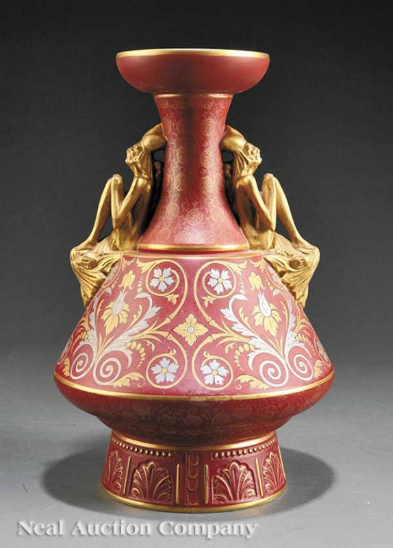 Christopher Dresser Earthenware Vase by Old Hall: A Christopher Dresser Earthenware Vase, c. 1886, by Old Hall, iron red ground with gold and silver foliate scrolls, figural handles of jesters, height 14 1/4 in. Note: Old restorations