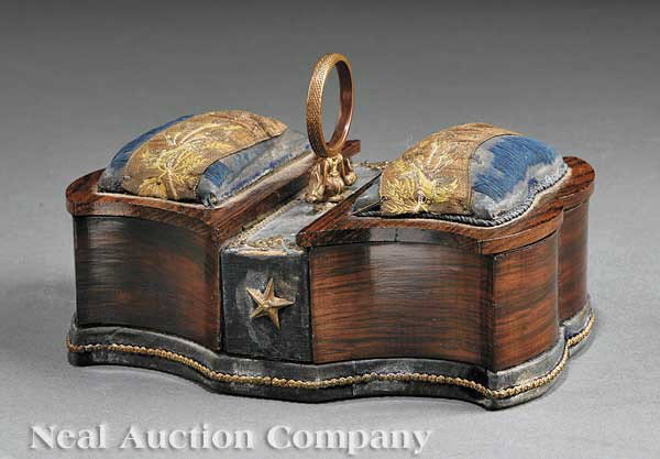 Regency Rosewood Bronze-Mounted Sewing Box: A Regency Rosewood Bronze-Mounted Sewing Box, c. 1820, shaped sides, the fitted compartment lids with pin cushions, molded caryying ring with phoenix head mounts, height 3 5/8 in., width 6 in., depth 