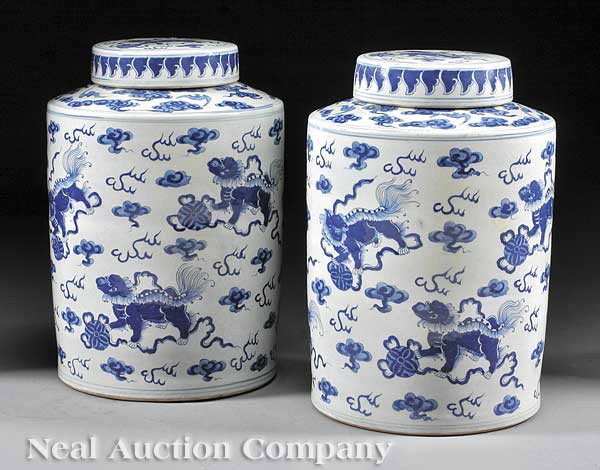 Chinese Blue and White Porcelain Covered Jars: A Pair of Chinese Blue and White Porcelain Covered Jars, drum form bodies with sloping shoulders, decorated with Buddhistic lions and brocade balls amid ruyi clouds, height 17 in