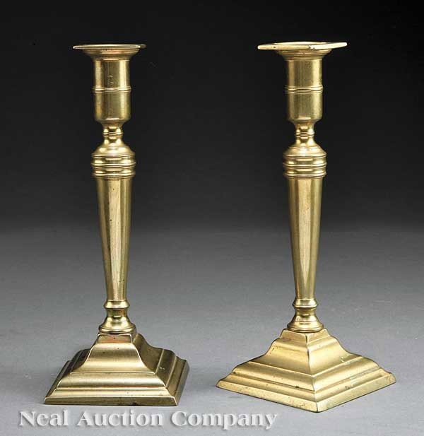 Pair of English Brass Candlesticks: A Pair of English Brass Candlesticks, early 19th c., with fixed square bobeches and ring-turned cup, above a tapered shaft set in a stepped square base with push up mechanism, height 9 5/8 in