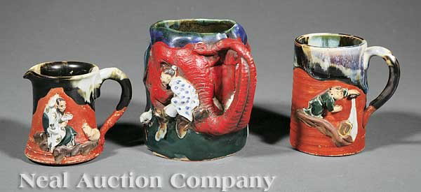 Group of Three Sumida Ware Table Articles: A Group of Three Sumida Ware Table Articles, early 20th c., red ground and flambe glaze, comprising a mug, porcelain cartouche signed "Ryosai", elephant trunk handle, relief decorated with a sage and 