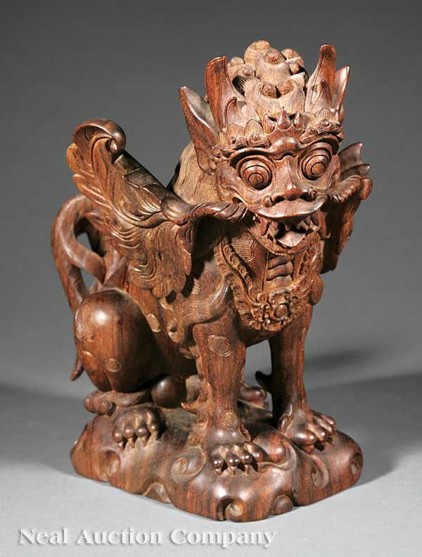Ida Bagus Tilem (Indonesian/Bali, b. 1936): Ida Bagus Tilem (Indonesian/Bali, b. 1936), "Mythical Lion", carved wood male figure seated on its back haunches carrying a large leafy branch in his mouth, incised decoration throughout, base inscrib