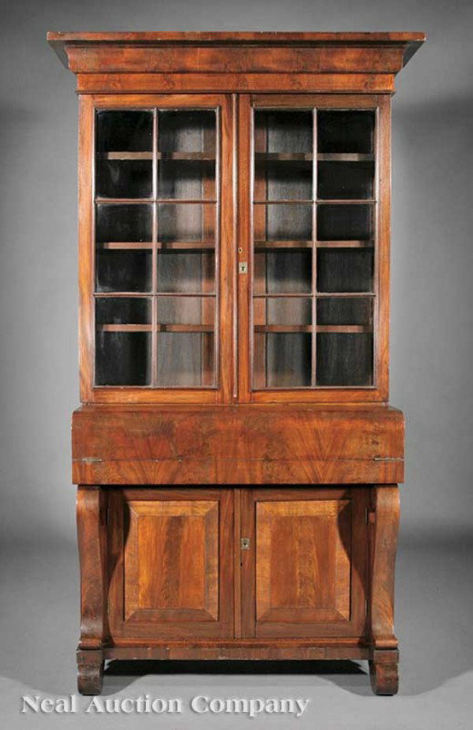 Late Classical Mahogany Secretary Bookcase: An American Late Classical Mahogany Secretary Bookcase, stepped ogee-molded cornice above a pair of paneled glazed doors and three drawers, adjustable shelves, base with foldover writing surface, scro