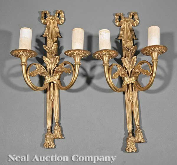 Gilt Brass and Bronze Two-Light Wall Sconces: A Pair of French Neoclassical Gilt Brass and Bronze Two-Light Wall Sconces, beribboned backplate issuing oak leaves and a pair of French horn candlearms with vintage decoration, electrified, height 16