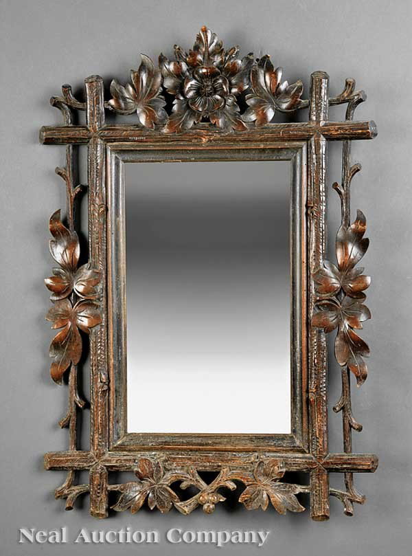 Black Forest Carved Walnut Mirror: An Antique Black Forest Carved Walnut Mirror, c. 1900, beveled mirror plate, branchwork frame carved with oak leaves and flowers, height 29 in., width 20 in