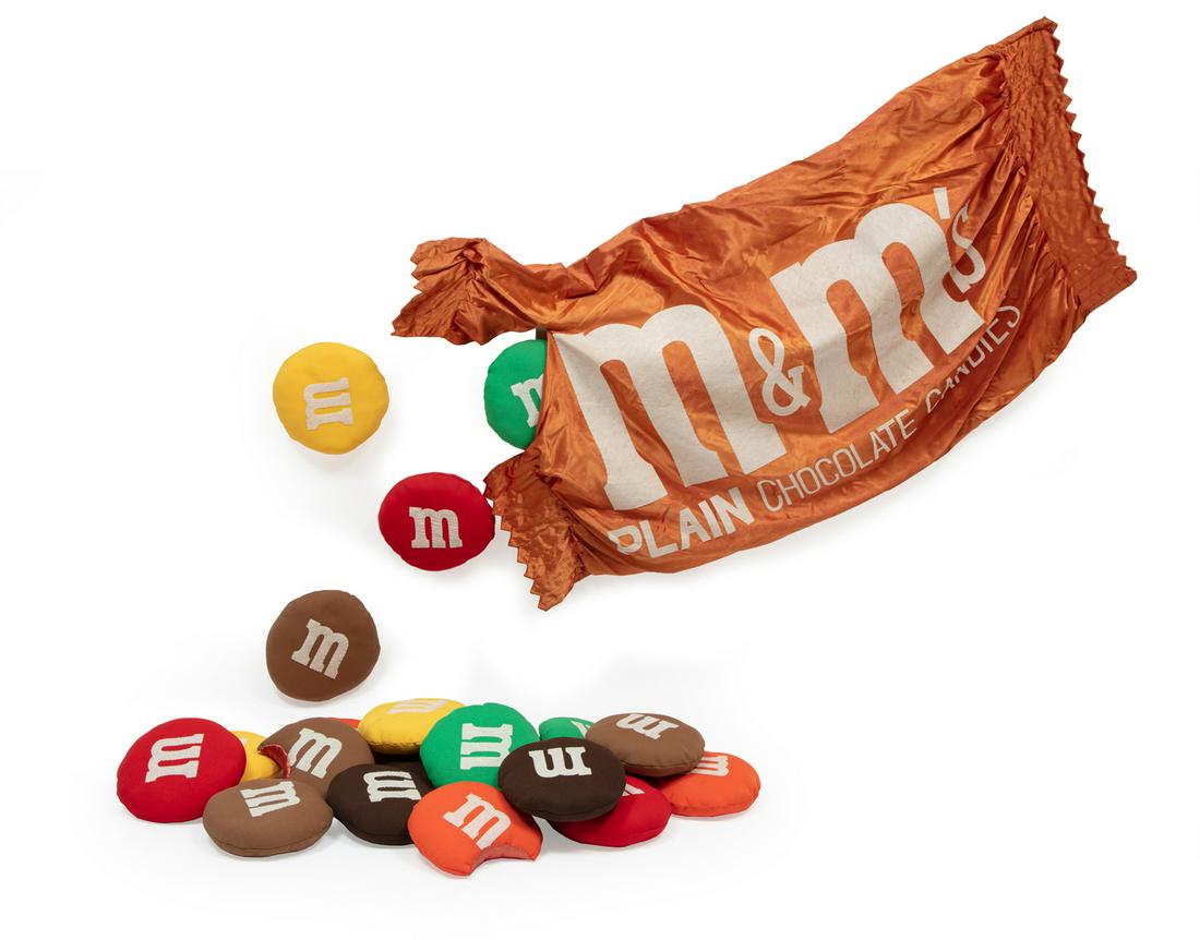 Linda Miller (American/California, 20th c.): Linda Miller (American/California, 20th c.), "M & M's Plain Chocolate Candies", 1983, mixed media soft wall sculpture, signed and dated en verso, bag approx. 28 in. x 54 in., each candy approx. dia. 8