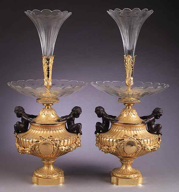 Louis XVI-Style Patinated and Gilt-Bronze Epergne: A Pair of Louis XVI-Style Patinated and Gilt-Bronze Figural Epergnes , with cut glass trumpet vase and bowl on an urn-form base with putti and floral swags, height 26 1/2 in., diameter 12 in * NO RETU