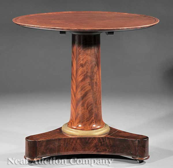 Bronze-Mounted Carved Mahogany Center Table: A French Gilt Bronze-Mounted Carved Mahogany Tilt-Top Center Table, c. 1825, circular molded top, columnar pedestal, incurvate triangular plinth, casters, height 27 1/4 in., diameter 28 1/4 in