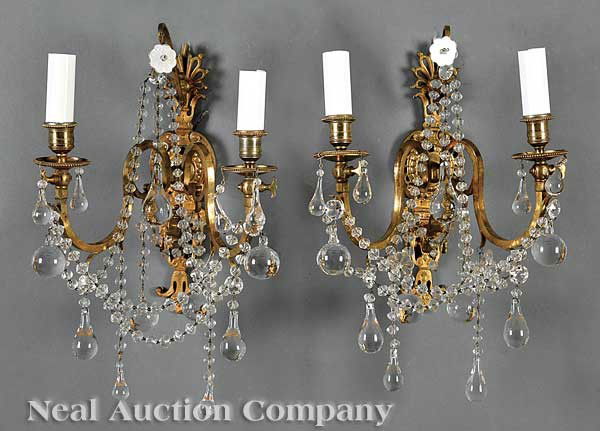 Pair of Gilt Bronze Two-Light Wall Sconces: A Pair of Gilt Bronze Two-Light Wall Sconces, anthemion mounted backplate with scrolled candlearms mounted with crystal swags and drop pendants, electrified, height 18 in., width 12 in., depth 9 in