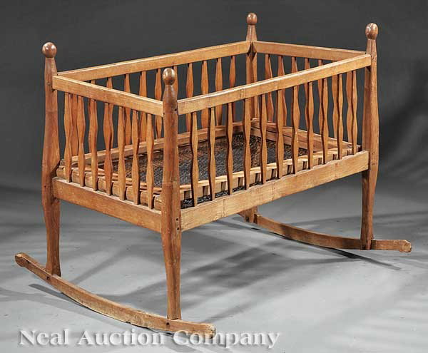 Acadian Carved Cypress Cradle: An Acadian Carved Cypress Cradle, late 19th c., having shaped uprights, flat spindled sides, wire mesh bottom, on rockers, height 32 1/2 in., width 40 in., depth 23 in