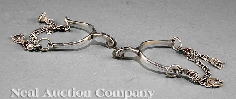 Mexican Sterling Silver Horseman's Spurs: A Pair of Mexican Sterling Silver Horseman's Spurs, 19th c., unmarked, each fitted with a small wheel (rowel), a "peso" coin, silver chains and buckles, weight 7.75 troy ozs