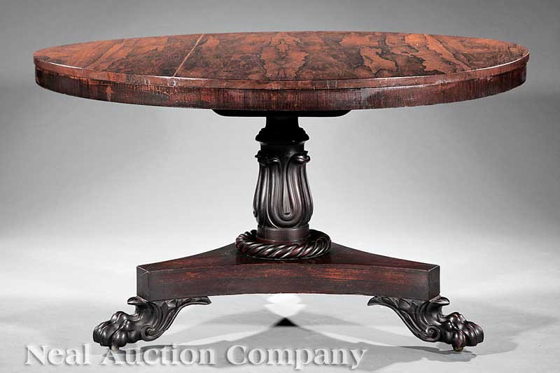 Regency Carved Rosewood Center Table: A Regency Carved Rosewood Center Table, early 19th c., circular tilt top, lotus-carved support with rope turned collar, incurvate plinth, leaf carved paw feet, casters, height 28 3/4 in., diameter 49 
