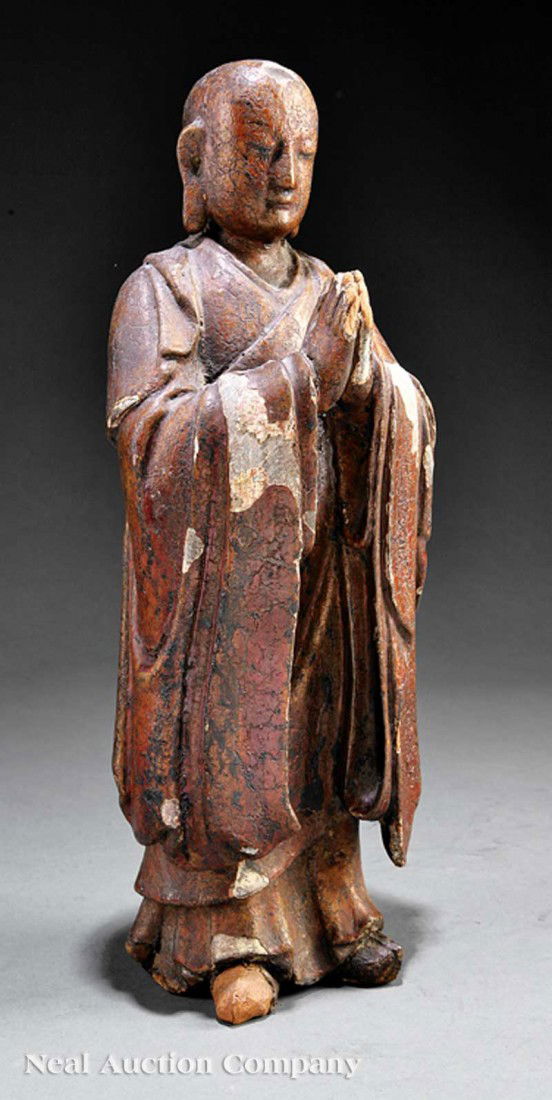 Chinese Polychromed, Gessoed Carved Wood Luohan: A Chinese Polychromed and Gessoed Carved Wood Figure of a Luohan, probably Ming Dynasty (1368-1644), the bald standing figure wearing long robes and holding both hands in anjali mudra at his chest, he