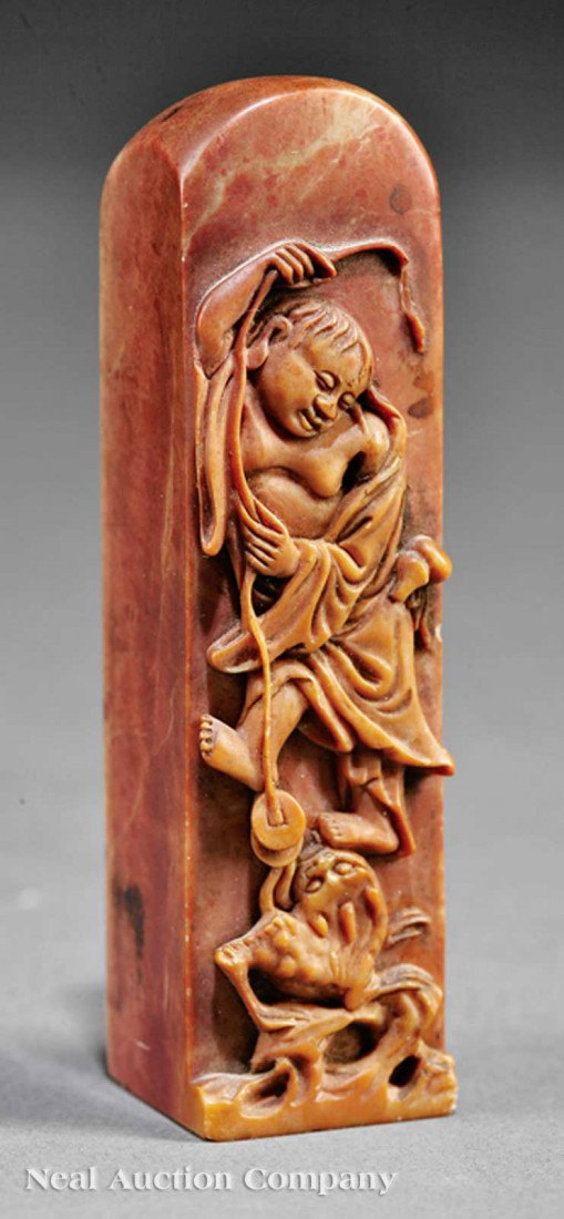 Chinese Soapstone Seal: An Antique Chinese Soapstone Seal, rectangular form with sloping rounded head, finely relief carved to one side with a scene of Liu Hai, the Daoist god of wealth and prosperity, playfully dangling a s
