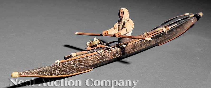 Inuit Wood, Leather and Bone Figure in a Kayak: An Inuit Wood, Leather and Bone Figure in a Kayak, with implements, detailed rendition, height 3 1/2 in., length 18 in., width 2 in