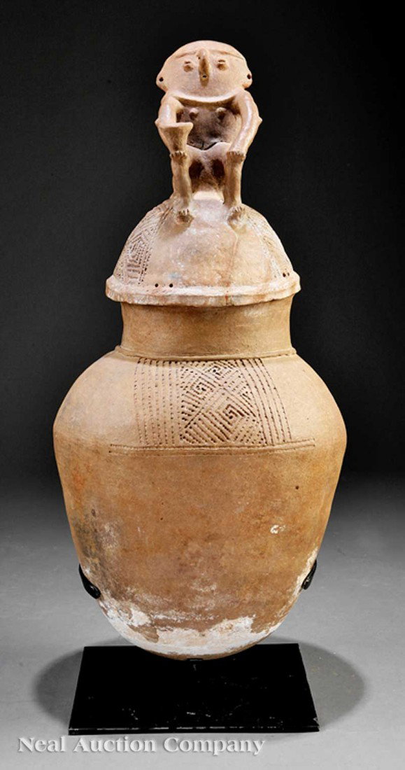 Pre-Columbian Pottery Jar and Cover: A Pre-Columbian Pottery Jar and Cover, c. 200-1500, Sinu, ovoid body with tall neck, domed cover surmounted by a seated female figure holding a bowl, height 30 in., metal display stand, overall height