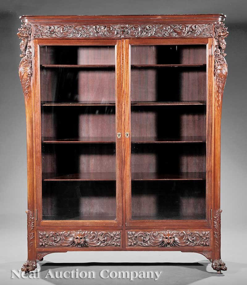 Carved Mahogany Bookcase, attrib. Horner: An American Belle Epoque Carved Mahogany Bookcase, late 19th/early 20th c., attributed to R.J. Horner, New York, molded cornice above scrolling vine frieze centered by a lion's mask, pair of glazed do