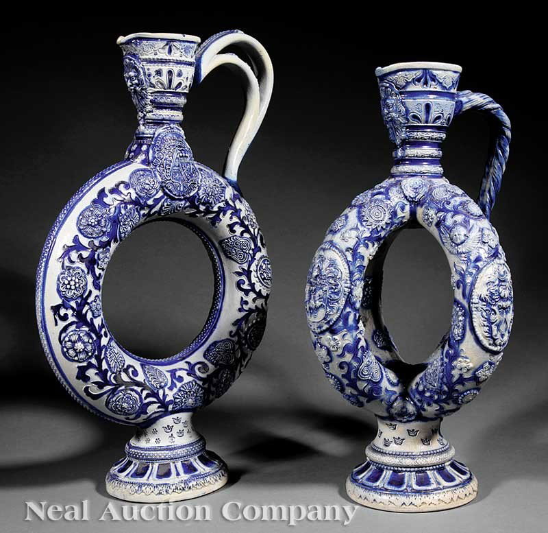 Two German Stoneware Puzzle Ewers: Two German Stoneware Puzzle Ewers, late 19th c., each with salt glaze cobalt relief designs, one single ring and one double ring, heights 17 5/8 in. and 15 5/8 in., respectively