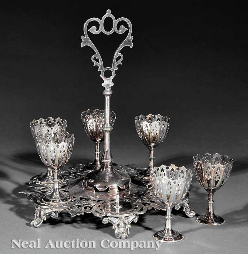 Silverplate Egg Cup Stand: An Antique Silverplate Egg Cup Stand, unmarked, with six cups, overall pierced decoration, scroll feet, height 6 1/4 in