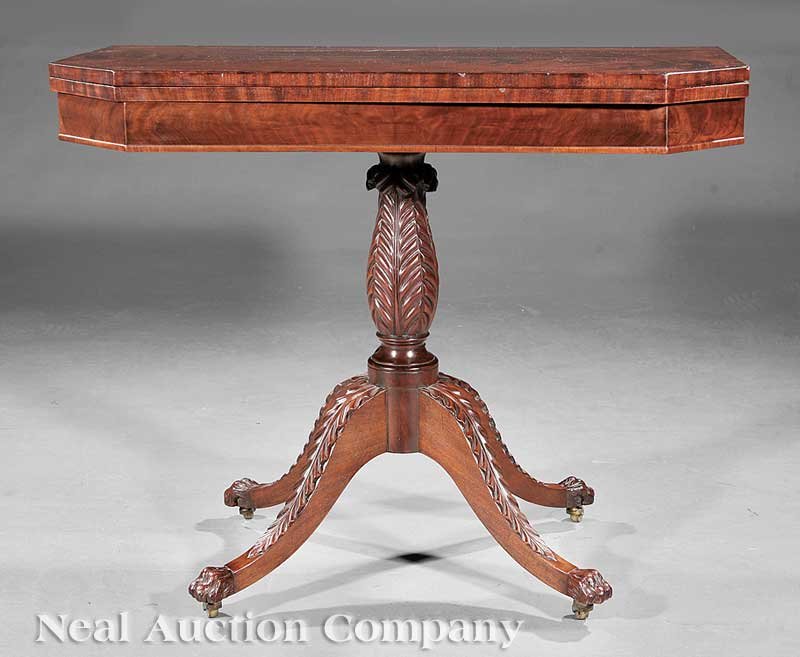 American Classical Carved Mahogany Games Tables: A Fine Pair of American Classical Carved Mahogany Games Tables, 19th c., New York, banded foldover swivel top with canted corners, acanthus-carved vasiform stem, arched acanthus legs ending in paw fee