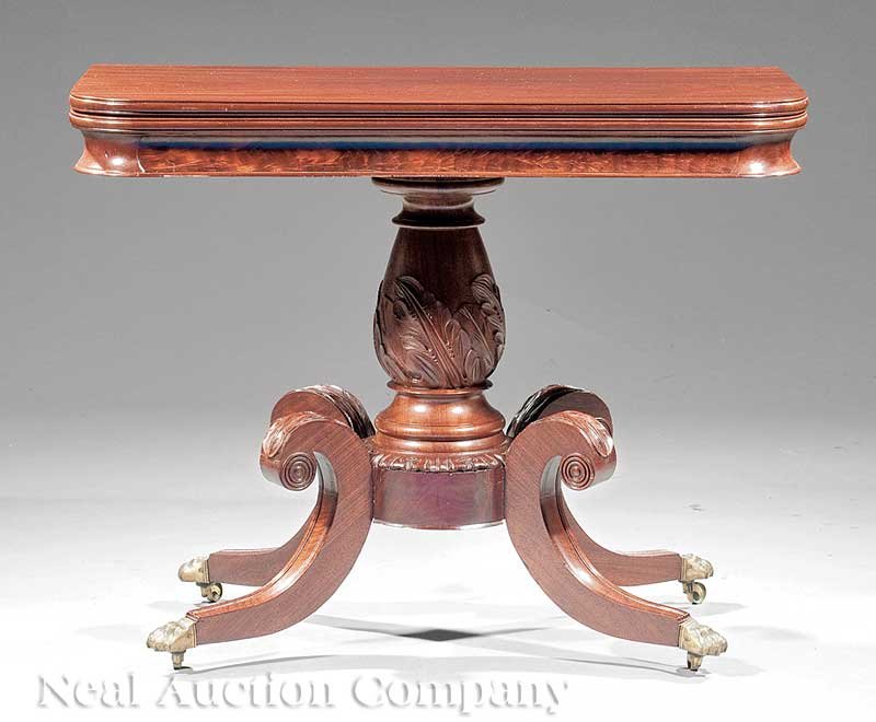 American Classical Carved Mahogany Games Table: An American Classical Carved Mahogany Games Table, c. 1825, Boston, fold-over swivel top, cove molded skirt, bulbous acanthus-carved support with drum plinth, hipped acanthus-carved sabre legs, brass 